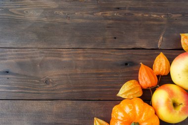 Sonbahar kavramı, ahşap arka plan sarı parlak Kabak elma ve physalis. Kopya alanı.