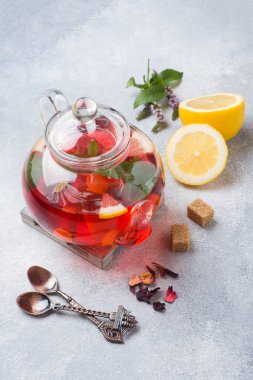 Cam demlik çay, nane ve limon ile kopya alanı gri tabloda.