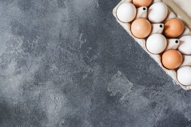 Karanlık bir acımasız tabloda bir karton kutu içinde tavuk yumurta