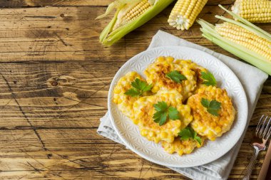 Maydanoz bir plaka üzerinde konserve mısır taneleri dan beşamel sos. Ahşap arka plan