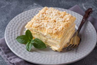 Koyu arka plan üzerine nane ile krem Napoleon yağlı vanilyalı dilim pastayla katmanlı