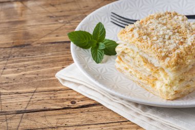 Ahşap zemin üzerine nane ile krem Napoleon yağlı vanilyalı dilim pastayla katmanlı