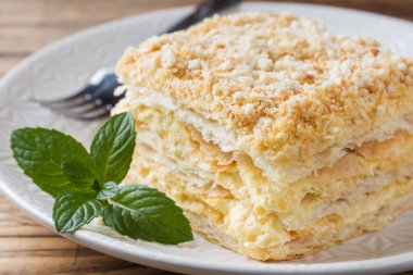 Ahşap zemin üzerine nane ile krem Napoleon yağlı vanilyalı dilim pastayla katmanlı