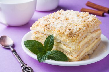 Puf kek krem Napoleon yağlı vanilyalı Slice mor zemin üzerine nane renkle