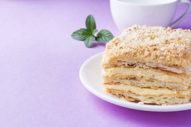 Puf kek krem Napoleon yağlı vanilyalı Slice mor zemin üzerine nane renkle