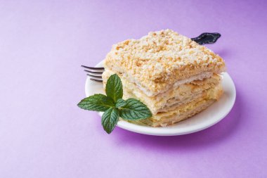 Puf kek krem Napoleon yağlı vanilyalı Slice mor zemin üzerine nane renkle