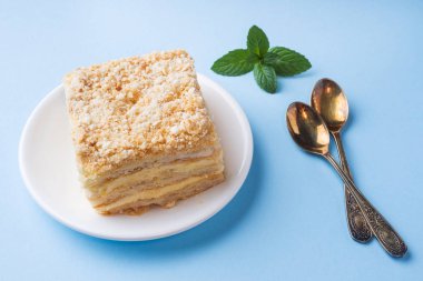 Mavi renkli bir arka plan üzerinde nane ile krem Napoleon yağlı vanilyalı dilim pastayla katmanı