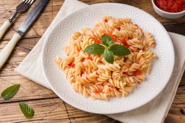 Kiraz domates ve domates sosu bir plaka üzerinde sarmal makarna karışık