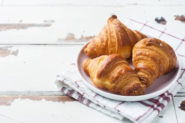 Bir tabak ve bir fincan kahve, ahşap arka plan, kahvaltı croissants alanı Kopyala