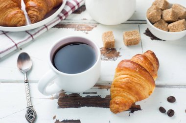 Bir tabak ve bir fincan kahve, ahşap arka plan, kahvaltı croissants alanı Kopyala