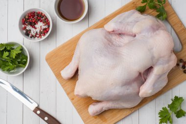 Tahtada taze çiğ tavuk ve pişirmek için baharatlar..