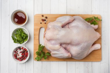 Tahtada taze çiğ tavuk ve pişirmek için baharatlar..