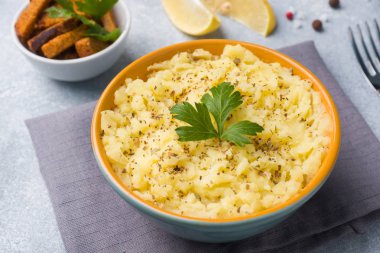 Otlar, kruton ve peçeteler bir tabağa limon ile patates püresi