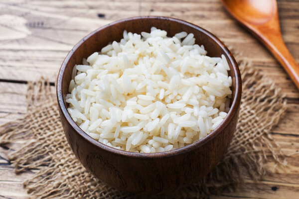 White boiled rice in a wooden bowl. Rustic style