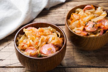 Sosis masada ahşap kase haşlanmış lahana. Seçici odak