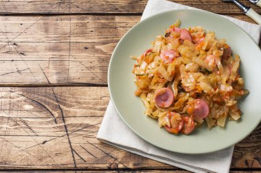 Masaya bir tabak içinde sosis ile haşlanmış lahana. Seçici odak