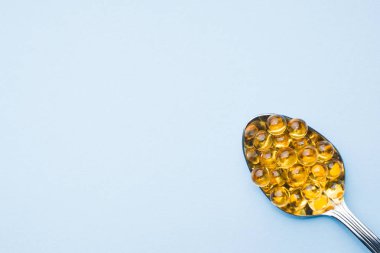 Balık yağı kapsülleri omega 3 ve D vitamini mavi doku, sağlıklı beslenme kavramı, seçici odak ile