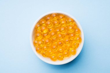 Balık yağı kapsülleri omega 3 ve D vitamini mavi doku, sağlıklı beslenme kavramı, seçici odak ile