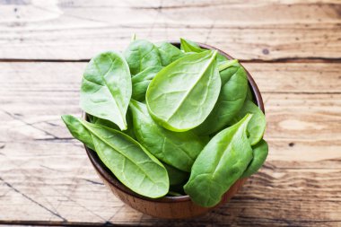 Taze ıspanak kapta rustik ahşap masanın üzerine bırakır.