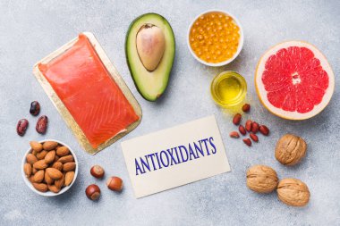 Sağlıklı gıda antioksidan ürünleri: balık ve avokado, fındık ve balık yağı, greyfurt gri beton zemin üzerine