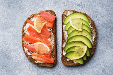 Ispanak ve avokado somon gri bir tablo ile açık sandviçler