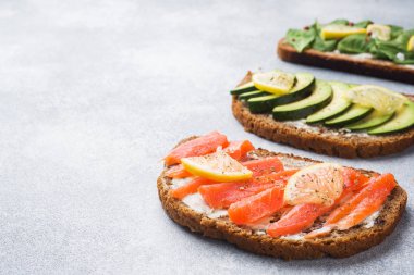 Açık bir gri ıspanak ve avokado somon sandviçle kopya alanı masa