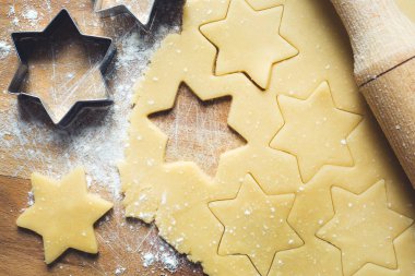 Noel kurabiyeleri yapmak için malzemeler. Oklava çerez kesici hamur hafif zemin üzerine tarçın un yumurta tereyağı alanı Kopyala