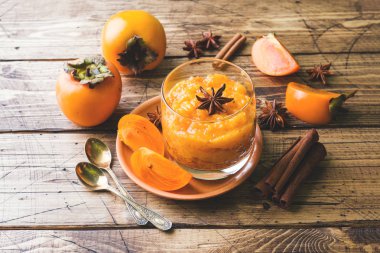 Trabzon hurması meyve yüzlü tarçın ve anason yıldız, ahşap masa.