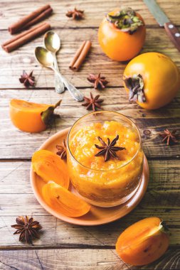 Trabzon hurması meyve yüzlü tarçın ve anason yıldız, ahşap masa.