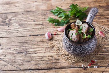 Pişmiş tavuk karaciğer ahşap rustik masa kopya alanı üzerinde seramik cocotte soğan ile.