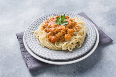 Spagetti makarna Bolognese masa beyaz plaka, gri üzerine.