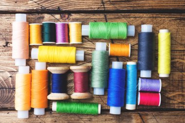 Satırlar halinde ahşap arka plan iş parçacığı renkli biriktiricileri düzenlendiği