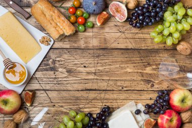 Peynir, şarap, baget üzüm incir bal ve rustik ahşap masa üstü kopya alanı ile snacks