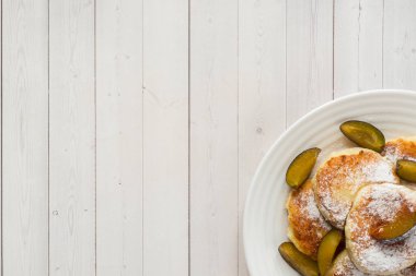 Peynirli Krep içinde bir plaka üzerinde taze erik ile pudra şekeri. Kopya alanı.