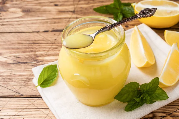Taze limon, rustik ahşap arka plan kopya alanı ile cam kavanozlara ev yapımı limon lor.