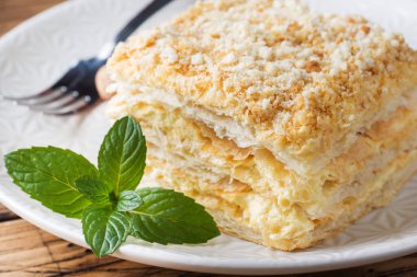 Ahşap zemin üzerine nane ile krem Napoleon yağlı vanilyalı dilim pastayla katmanlı