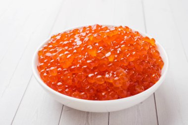 Kırmızı somon havyar beyaz masaya bir tabak içinde
