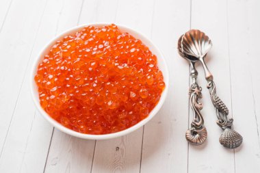 Kırmızı somon havyar beyaz masaya bir tabak içinde