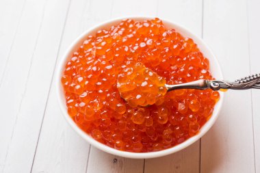 Kırmızı somon havyar beyaz masaya bir tabak içinde