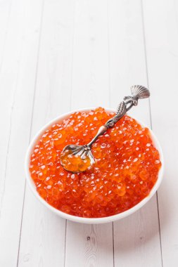 Kırmızı somon havyar beyaz masaya bir tabak içinde