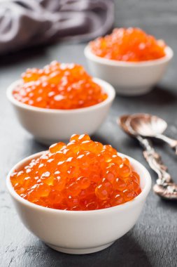 Kırmızı somon havyar karanlık bir masaya bir tabak içinde