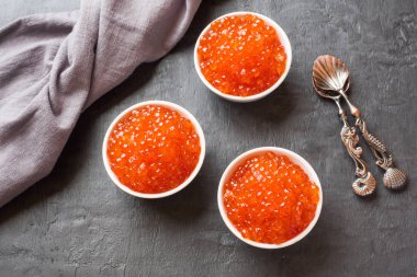 Kırmızı somon havyar karanlık bir masaya bir tabak içinde