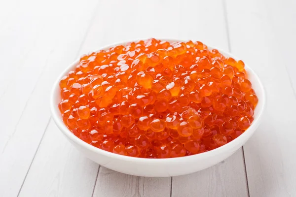 Kırmızı somon havyar beyaz masaya bir tabak içinde