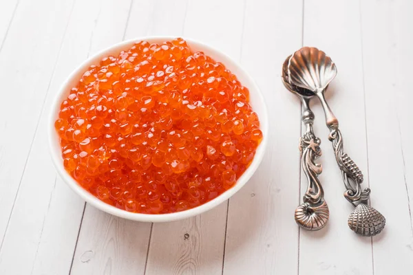 Kırmızı somon havyar beyaz masaya bir tabak içinde