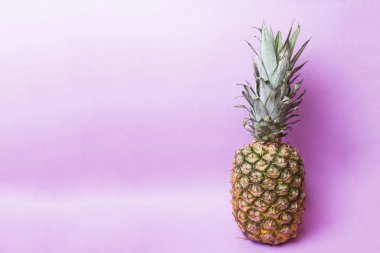 Ripe pineapple on a pink toned background. Copy space.
