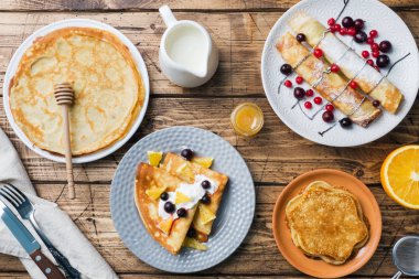 Krep ahşap bir masa üzerinde çilek ile farklı türleri.