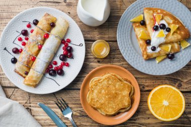 Krep ahşap bir masa üzerinde çilek ile farklı türleri.