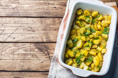 Baharat ve otlar bir seramik fırın tepsisinde ile fırında patates. Vejetaryen mutfağı kopya alanı