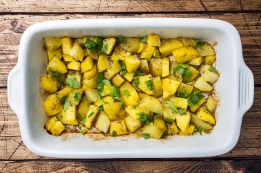 Baharat ve otlar bir seramik fırın tepsisinde ile fırında patates. Vejetaryen mutfağı