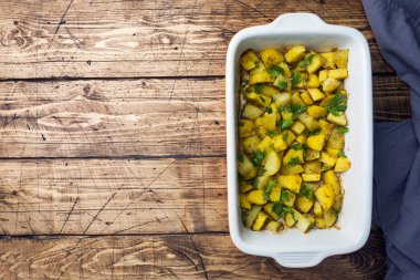 Baharat ve otlar bir seramik fırın tepsisinde ile fırında patates. Vejetaryen mutfağı kopya alanı